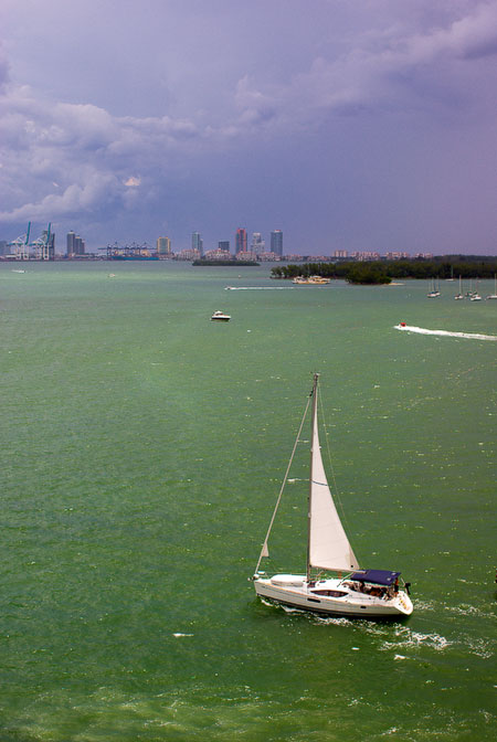 sailboat entering harbor ahead of storm